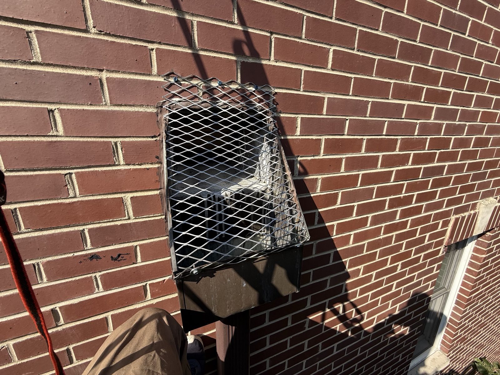 Bird screen on a leader head above a downspout on a brick wall, Near North Side, Chicago